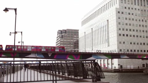 Docklands Light railway train passes buildings in Canary Wharf 動画素材 61887316