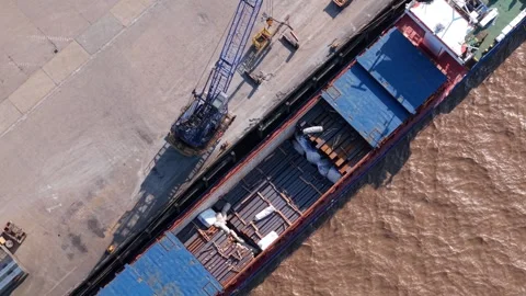 Dockside crane loading bulk cargo into a ship hold on River Trent, aerial Stock Footage 346653349