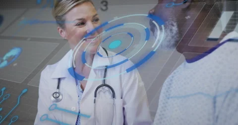 Doctor accessing blue holographic interface in clinic while reviewing vitals and Stock Footage 316186484