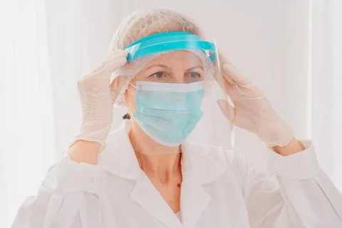 Doctor adjust the face protector screen against covid-19 virus Stock Photos