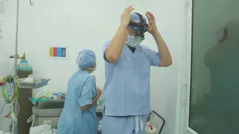 Doctor adjusting the head light getting ready for the surgery in operating room Stock Footage 77449436