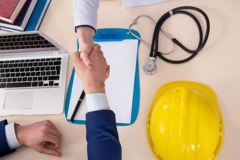 Doctor and manager agreeing industrial insurance coverage Stock Photos