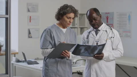 Doctor and Medical Apprentice Analyzing Chest X-Ray Stock Footage 254485968