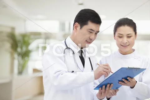 Doctor and Nurse Looking at Medical Record Stock Photos