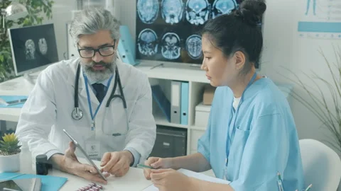 Doctor and nurse using tablet touching screen and talking working in hospital Stock Footage 172323732
