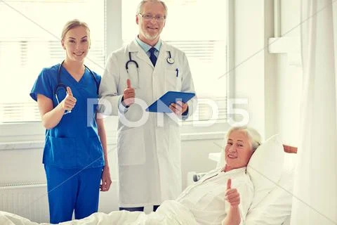 Doctor and nurse visiting senior woman at hospital Stock Photos