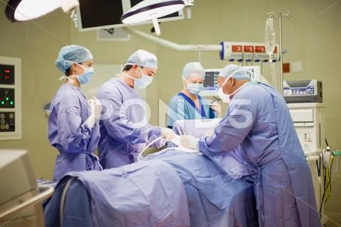 Doctor And Nurses Performing Operation