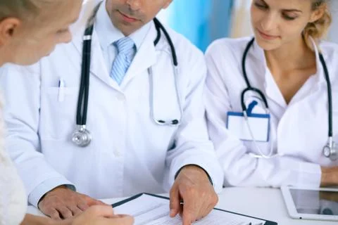 Doctor and  patient talking while sitting at the desk in office. Physicia Stock Photos