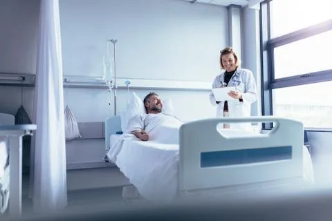Doctor attending sick patient in hospital bed Stock Photos