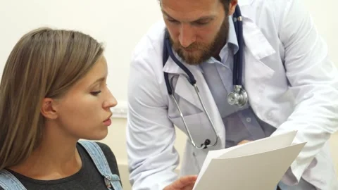 Doctor attentively explaining recommendations to a young female patient Stock Footage 311981198