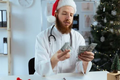 Doctor bearded man on the shift counting money for financial investment and Stock Photos