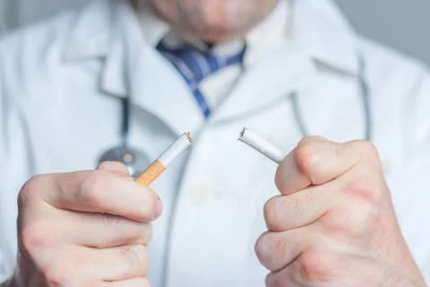 Doctor breaking a cigarette Stock Photos