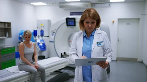 Doctor checking CT scan results in front of patient in imaging room. Stock Footage 313793391