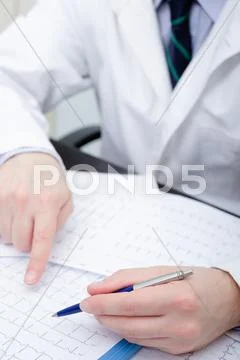 Doctor checking an electrocardiogram papers Stock Photos