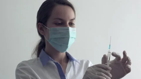 Doctor checking filled syringe with fluid Stock Footage 137122212