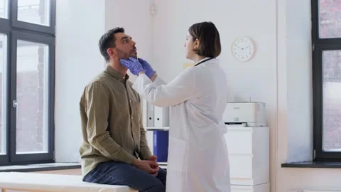Doctor checking lymph nodes of patient at hospital Stock Footage 195315684