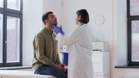 Doctor checking lymph nodes of patient at hospital Stock Footage 196865464