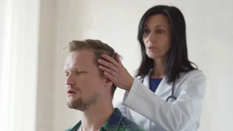 Doctor checking neck of middle aged patient Stock Footage 142663453