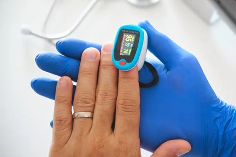 Doctor checking patient oxygen saturation with pulse oximeter Stock Photos