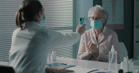 Doctor checking a patient's body temperature using a infrared thermometer Stock Footage 151263419