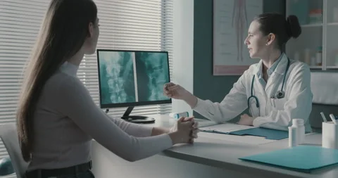 Doctor checking a patient's x-ray during a visit Stock Footage 151232353