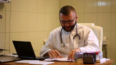 Doctor checking results in the office and telling good news to the camera Stock Footage
