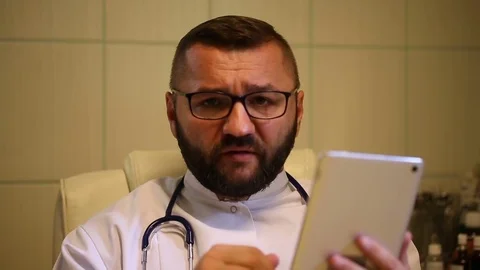 Doctor checking results in the tablet and tells bad news Stock Footage 77884454