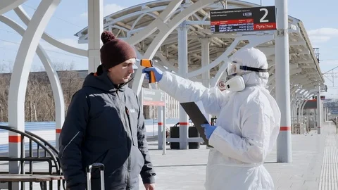 Doctor checking screening temperature of passengers for coronavirus symptoms. Video stock 127252264