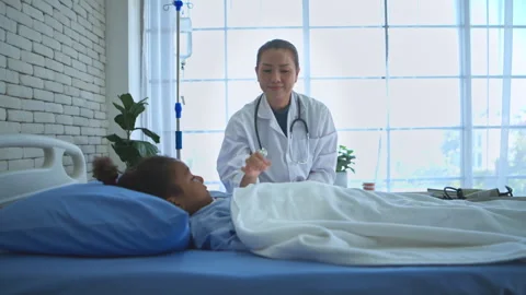 Doctor checking temperature and assessing condition of young girl 스톡 동영상 339069926