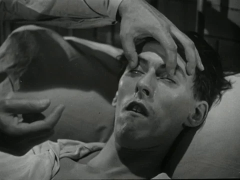 Doctor checking up on young ill man, explaining diagnosis of illness, UK 1947 Stock Footage 134033287
