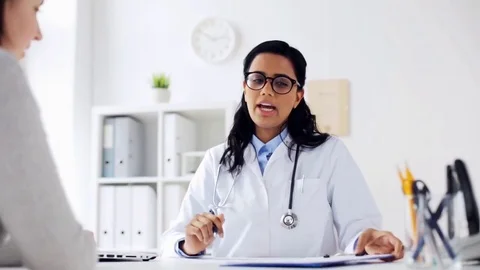 Doctor with clipboard and laptop and woman Stock Footage