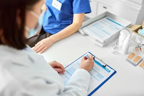 Doctor with clipboard and nurse at hospital Stock Photos