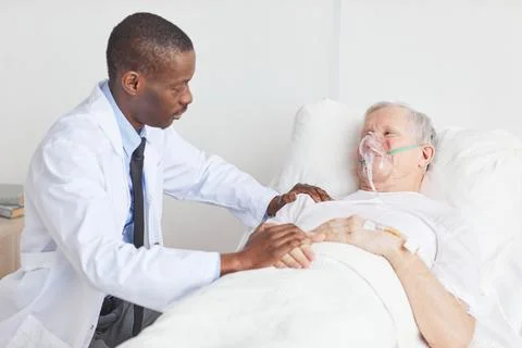 Doctor Comforting Senior Man in Hospital Stock Photos