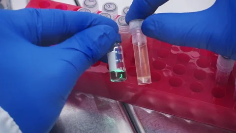 Doctor compares two test tubes with liquids. Stock Footage 241088048