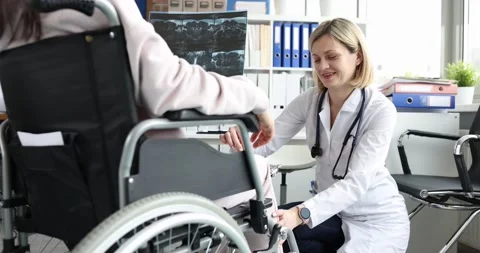 Doctor conducts study of the patellar reflex on knee of patient in wheelchair Stock Footage 174131405