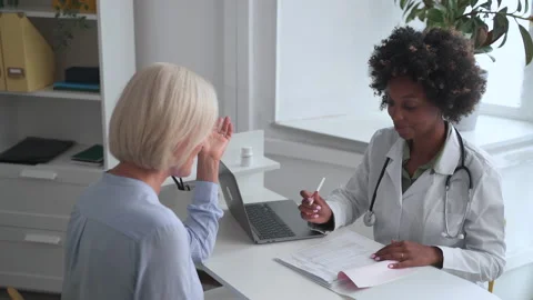 Doctor consulting at appointment black therapist fills forms Spbas Stock Footage