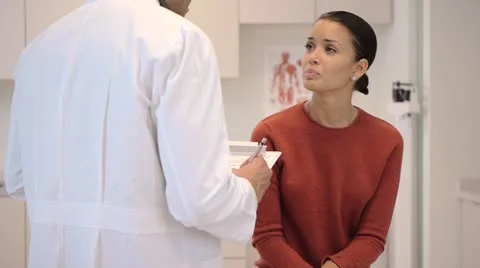 Doctor consulting patient in exam room Stock Footage