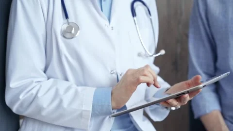 Doctor consulting patient using digital tablet in clinic. Medicine and health Stock Footage 270254497