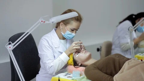 The doctor-cosmetologist performs the procedure of correction and escalating of Stock Footage 84589068