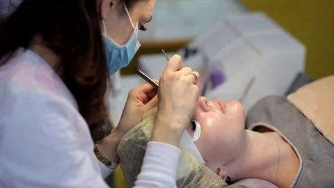The doctor-cosmetologist performs the procedure of correction and escalating of Stock Footage 84589211