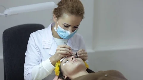 The doctor-cosmetologist performs the procedure of correction and escalating of Video stock 84589425