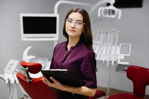 Doctor dentist working in office, using clipboard and making notes Stock Photos