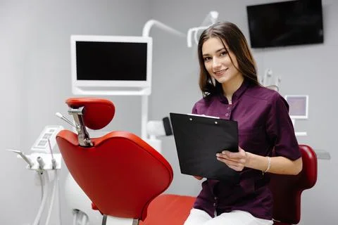 Doctor dentist working in office, using clipboard and making notes Stock Photos