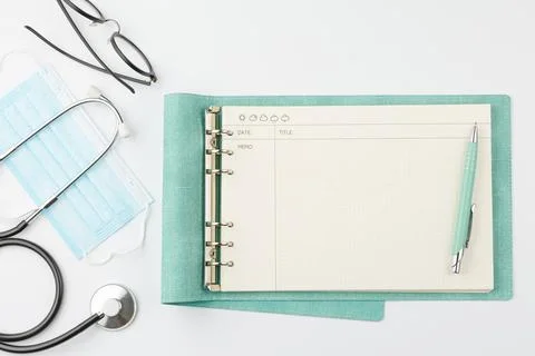 Doctor desk. Notebook with stethoscope and mask. Stock Photos