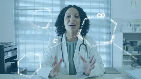Doctor at desk speaking, gesturing while molecular hexagons crossing face torso Stock Footage 334322163
