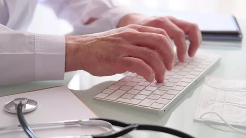 Doctor at the desk typing on the keyboard Stock Footage 127394111