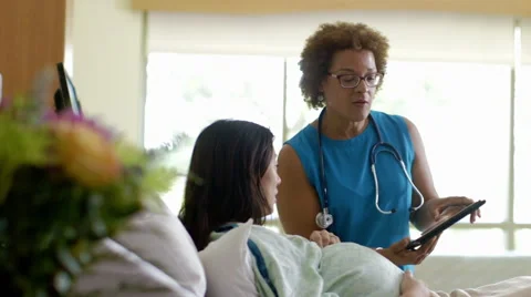 Doctor with digital tablet talking with expectant mother in hospital room Video stock 67177068