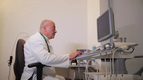 A doctor diligently working at a computer in a modern medical office environment Stock Footage 304939201