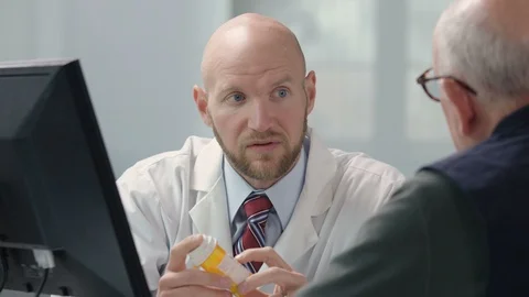 Doctor discussing medication with senior male Stock Footage