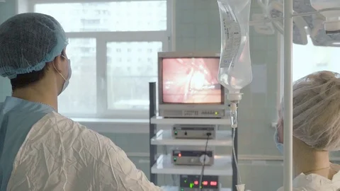 The doctor does the operation using the manipulators, he looks at the monitor Video stock 91743857